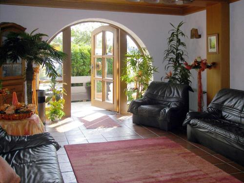 a living room with leather couches and an open door at Landhotel Spessartruh in Frammersbach