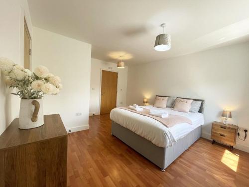 a bedroom with a bed and a vase of flowers at 17 Ocean one in Newquay