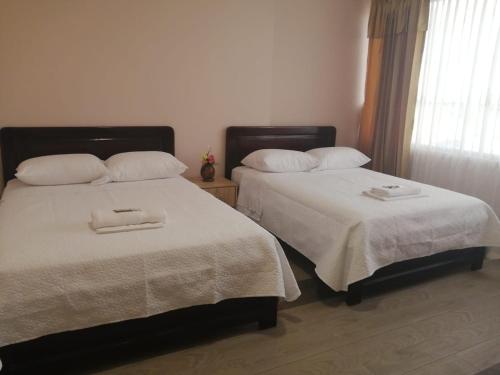 two beds sitting next to each other in a bedroom at Hotel Torre Orquídea in Puerto Francisco de Orellana