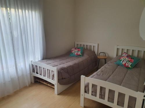 1 dormitorio con 2 camas y ventana en Casa Golfo Nuevo en Puerto Madryn