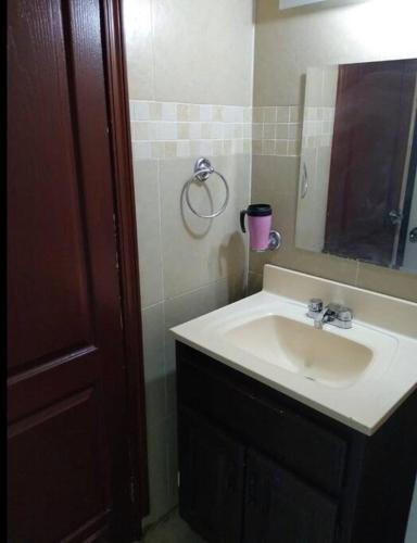 a bathroom with a sink and a mirror at Capistrano Suites in Hermosillo