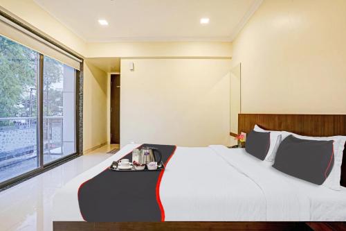 a large bed in a room with a large window at Sai Vidisha Palace in Shirdi