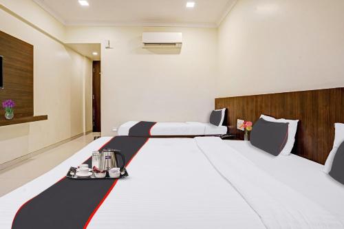 a hotel room with a large bed with a red and white blanket at Sai Vidisha Palace in Shirdi