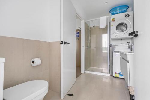 a bathroom with a toilet and a shower at Cool Ra-mada Hideaway with air-con and deck in Auckland