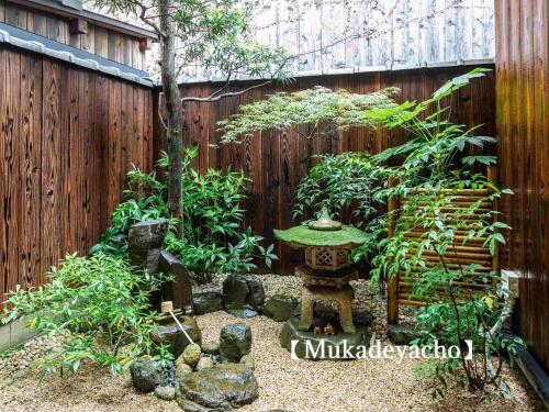 un jardin avec un banc en face d'une clôture dans l'établissement Kyoisuke, à Kyoto