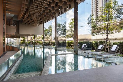 a pool in the middle of a building at Oakwood Suites Tiwanon Bangkok in Nonthaburi