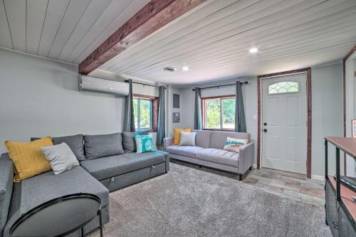 sala de estar con sofá y mesa en Prudenville Retreat with Yard about 1 Mi to Lake!, en Houghton Lake
