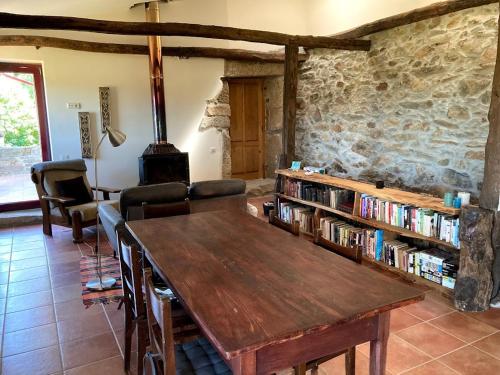 a room with a wooden table and a book shelf with books at Casa da Belavista in Vilar de Nantes
