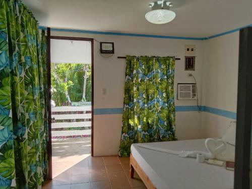 1 dormitorio con cama y ventana grande en RedDoorz @ Isla Virginia Beach Resort Aurora Baler, en Baler