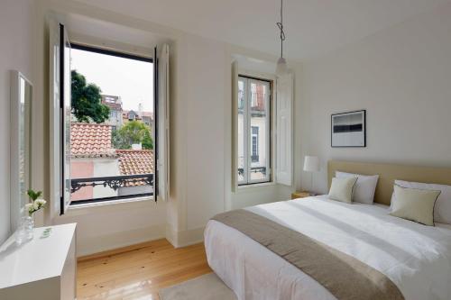 リスボンにあるFLH Santa Catarina Outstanding Flatsの白いベッドルーム(大型ベッド1台、窓付)