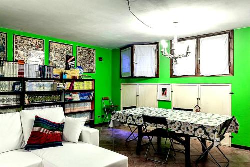 Habitación verde con mesa y sofá en Tavernetta con camino in collina, en Pianoro