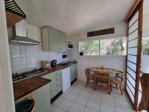 a small kitchen with a table and a window at Bellshala bungalow in Bellbrae