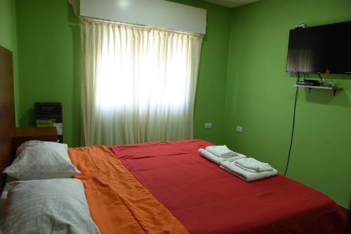 a green bedroom with a bed with a colorful blanket at Luisito in Santa Rosa