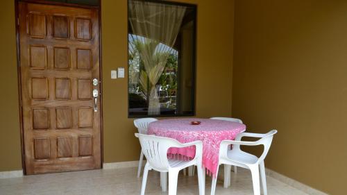 a table with two chairs and a pink table cloth at Villa Creole in Jacó