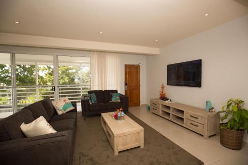 a living room with two couches and a tv at Gateway Hotel in Port Moresby