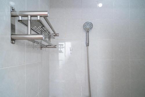 a shower with a shower head in a bathroom at RedDoorz @ Aralia Harapan Indah in Pulokendal