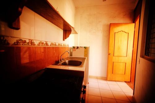 a small kitchen with a sink and a door at Hotel Yurimar in Puerto Escondido