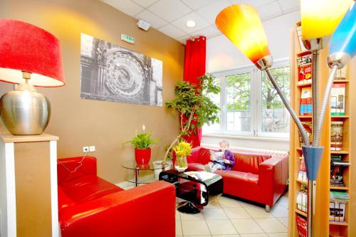 - un salon avec des meubles rouges et un enfant assis sur un canapé rouge dans l'établissement Charles Central, à Prague