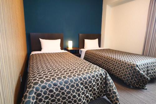 una habitación de hotel con 2 camas en una habitación en HOTEL THE GARDEN Ⅵ ICHINOMIYA, en Ichinomiya