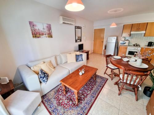 a living room with a couch and a table at Dock Holiday Apartment in Larnaka