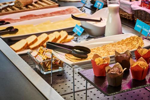 een buffet gevuld met verschillende soorten brood en gebak bij Kyriad Direct Lyon Sud - Chasse-Sur-Rhône in Chasse-sur-Rhône