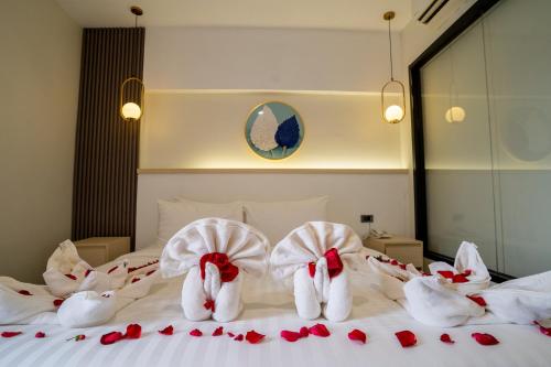 a bed with white towels and red roses on it at Hak Heng Hotel in Krong Poi Pet