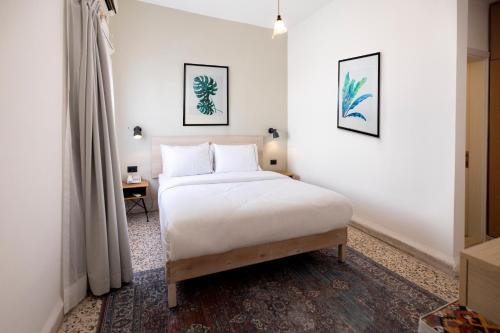 a bedroom with a white bed and a table at Julia's Hotel Suites in Amman