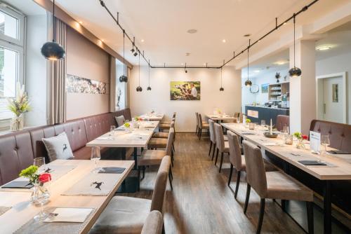 una fila de mesas y sillas en un restaurante en Arberland Tagungshaus, en Regen