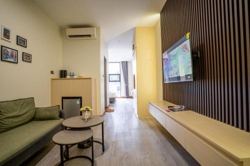 uma sala de estar com um sofá e uma televisão na parede em Hak Heng Hotel em Krong Poi Pet