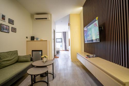 a living room with a couch and a tv on a wall at Hak Heng Hotel in Krong Poi Pet