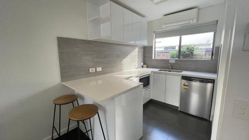 a kitchen with a white counter top and white cabinets at Coastal Motel in Apollo Bay