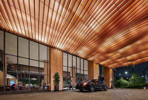 a car parked in front of a building with a wooden ceiling at PARKROYAL COLLECTION Kuala Lumpur in Kuala Lumpur