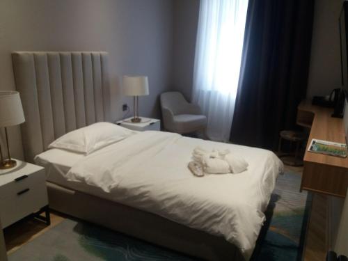 a bedroom with a bed with a stuffed animal on it at Termez Palace Hotel & Spa in Termiz