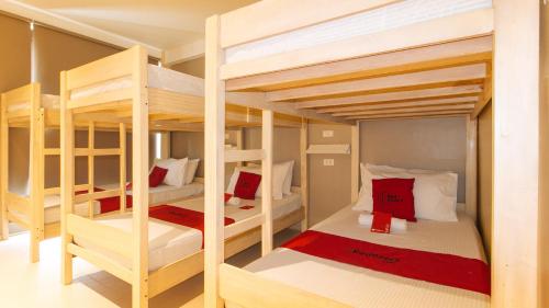 Habitación con 4 literas y almohadas rojas y blancas. en RedDooorz @ Laiya Vivo Hotel Batangas, en San Juan