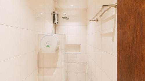 La salle de bains blanche est pourvue d'une douche et de toilettes. dans l'établissement RedDooorz @ Laiya Vivo Hotel Batangas, à San Juan