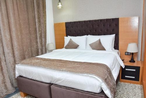 a bedroom with a large bed with a wooden headboard at Ramada by Wyndham Turkistan in Türkistan