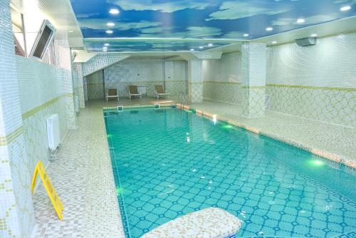 a large indoor swimming pool in a building at Ramada by Wyndham Turkistan in Türkistan