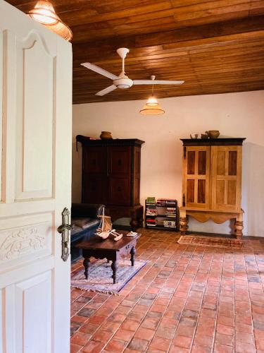 a living room with a ceiling fan and a table at Whispering House in Tangalle