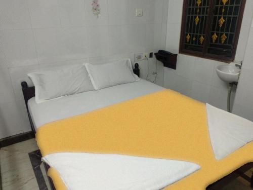 un grande letto in una stanza con lavandino di Vijaya Rooms a Tiruchchirāppalli