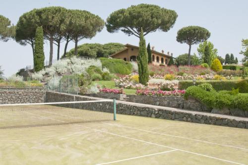 a tennis court in a garden with flowers and trees at Tenuta Cusmano in Grottaferrata