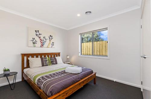 a bedroom with a bed and a window at Park View in Port Fairy