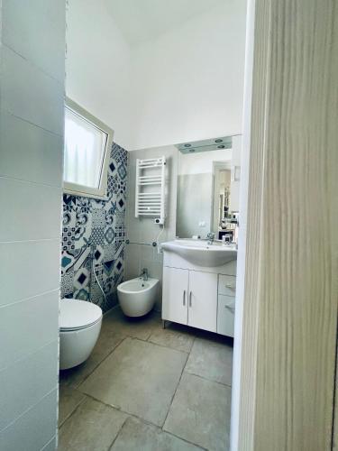 a bathroom with a sink and a toilet and a tub at A 2 passi dal mare Torre Faro LA PUNTA SeaHouse in Torre Faro