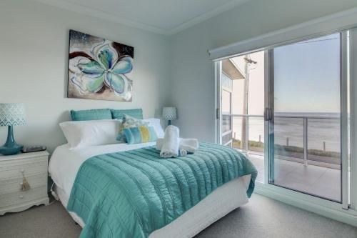 a bedroom with a bed and a large window at Sandy Cove in Port Fairy