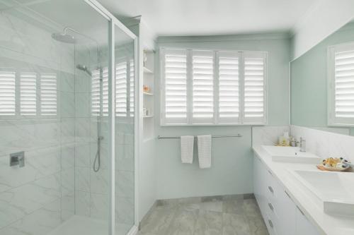 a bathroom with a shower and a sink and a mirror at Sandy Cove in Port Fairy