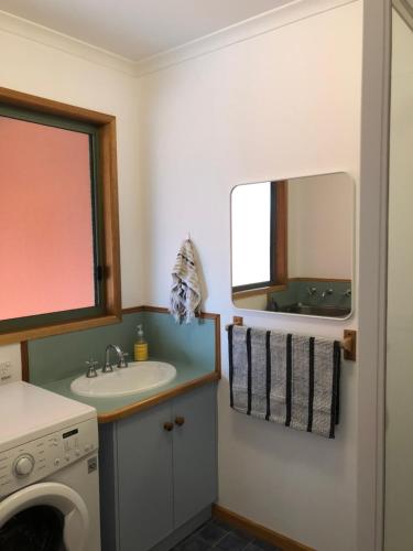 a bathroom with a sink and a washing machine at Seahorse Coastal Villas in Peterborough