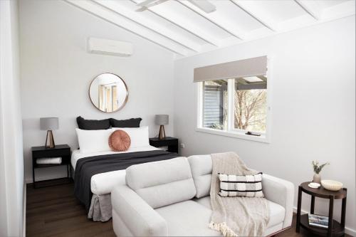 a white bedroom with a bed and a white couch at Pokolbin Farm Stay in Pokolbin