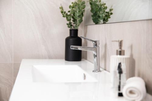 a bathroom sink with a black vase with a plant on it at Pokolbin Farm Stay in Pokolbin