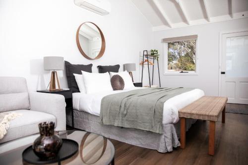 a white bedroom with a bed and a couch at Pokolbin Farm Stay in Pokolbin