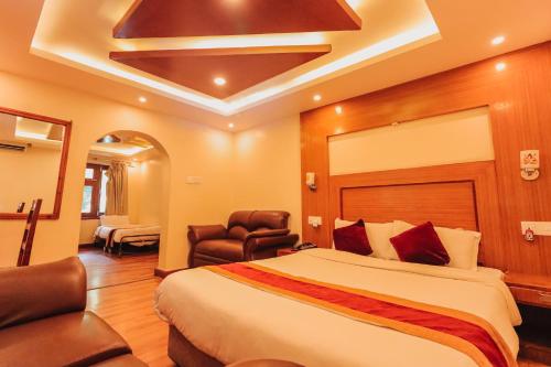 ein Hotelzimmer mit einem Bett und einem Stuhl in der Unterkunft Everland Kathmandu Hotel in Kathmandu