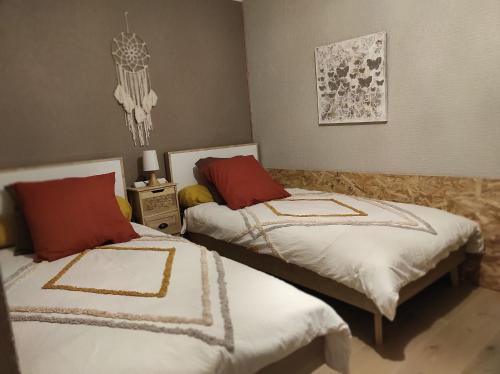 1 dormitorio con 2 camas con sábanas rojas y blancas en Gîte des 3 arbres, en Aramits